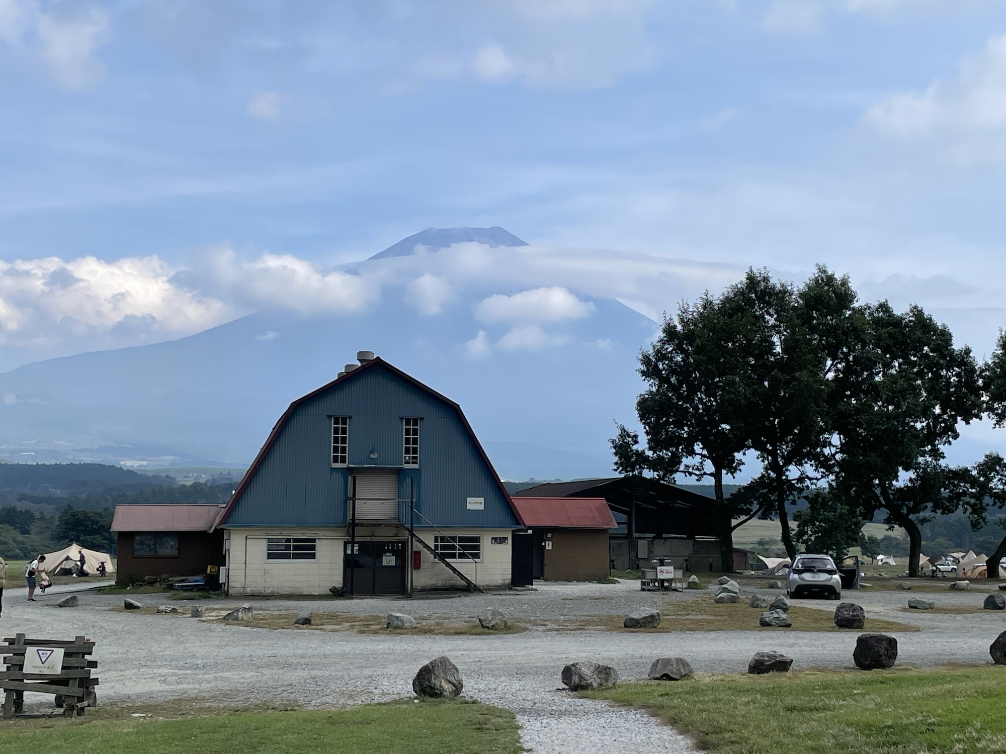 牛舎と富士山を背景にしたふもとっぱらキャンプ場の写真